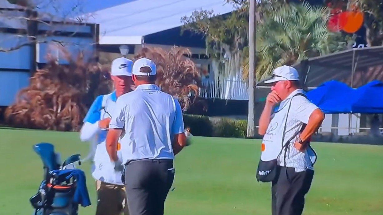Larson (right) looking at Scheffler's club