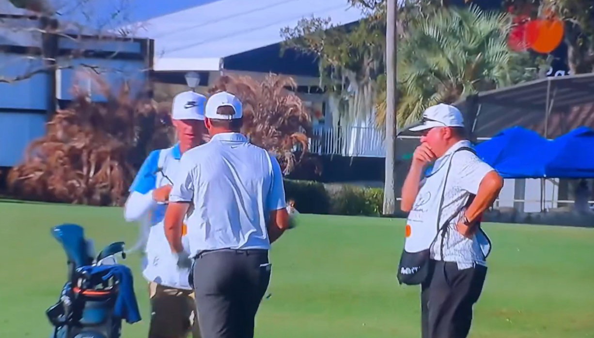 Larson (right) looking at Scheffler's club