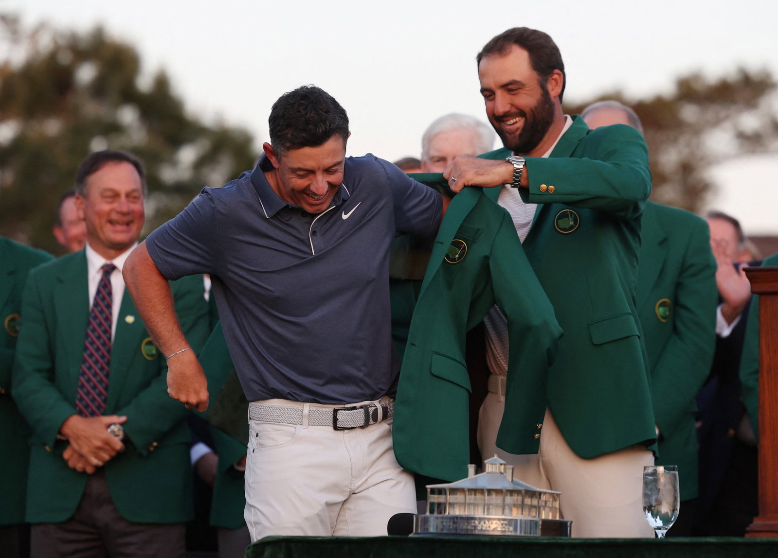 Scottie Scheffler slips the green jacket on Rory McIlroy