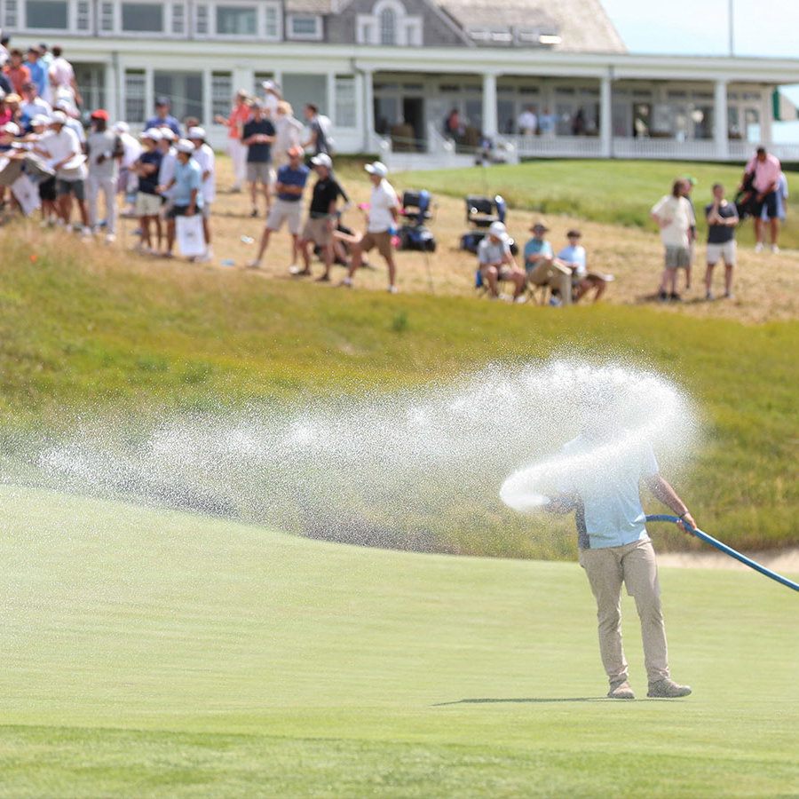 Grounds crew water the green on hole 18 during a practice round for the U.S. Open at Shinnecock Hills. Image: Reuters