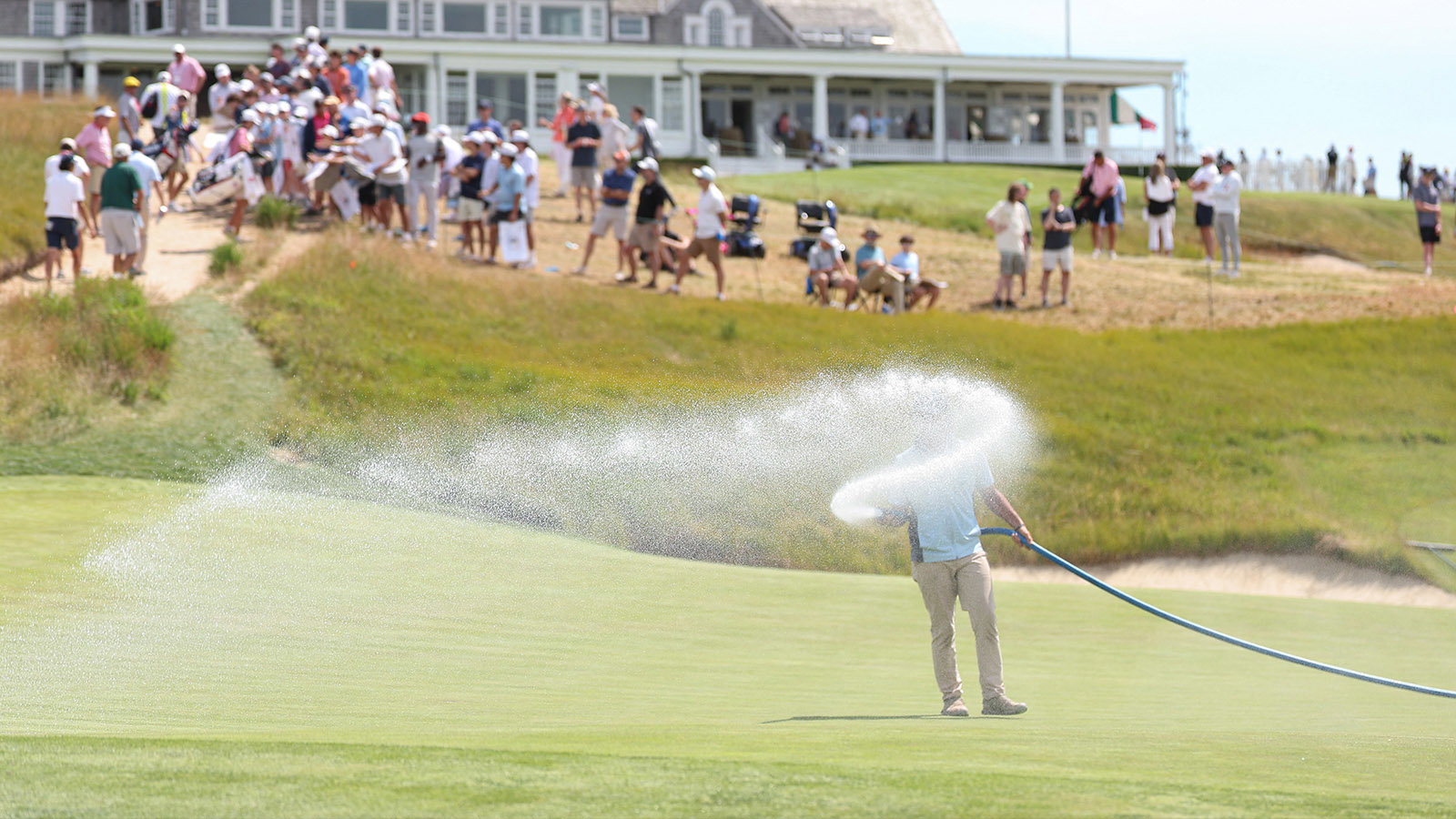 Grounds crew water the green on hole 18 during a practice round for the U.S. Open at Shinnecock Hills. Image: Reuters