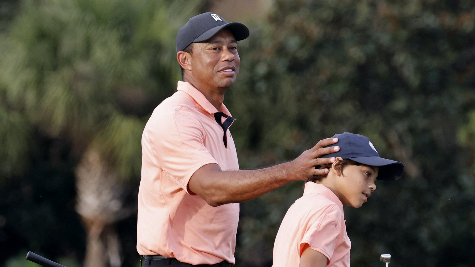 Charlie Woods looks unrecognisable as Tiger Woods returns to caddying duties