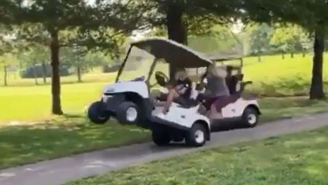 Golfers do a WHEELIE in golf cart before tipping it over